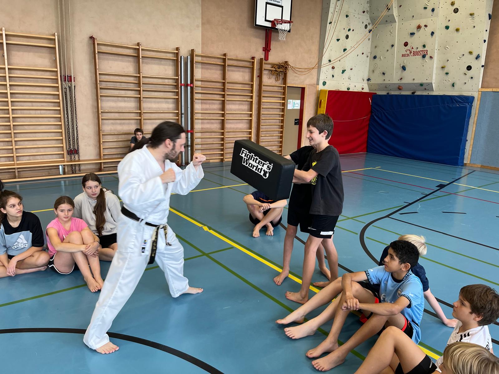 Zwei Schüler halten Schlagpolster für Markus